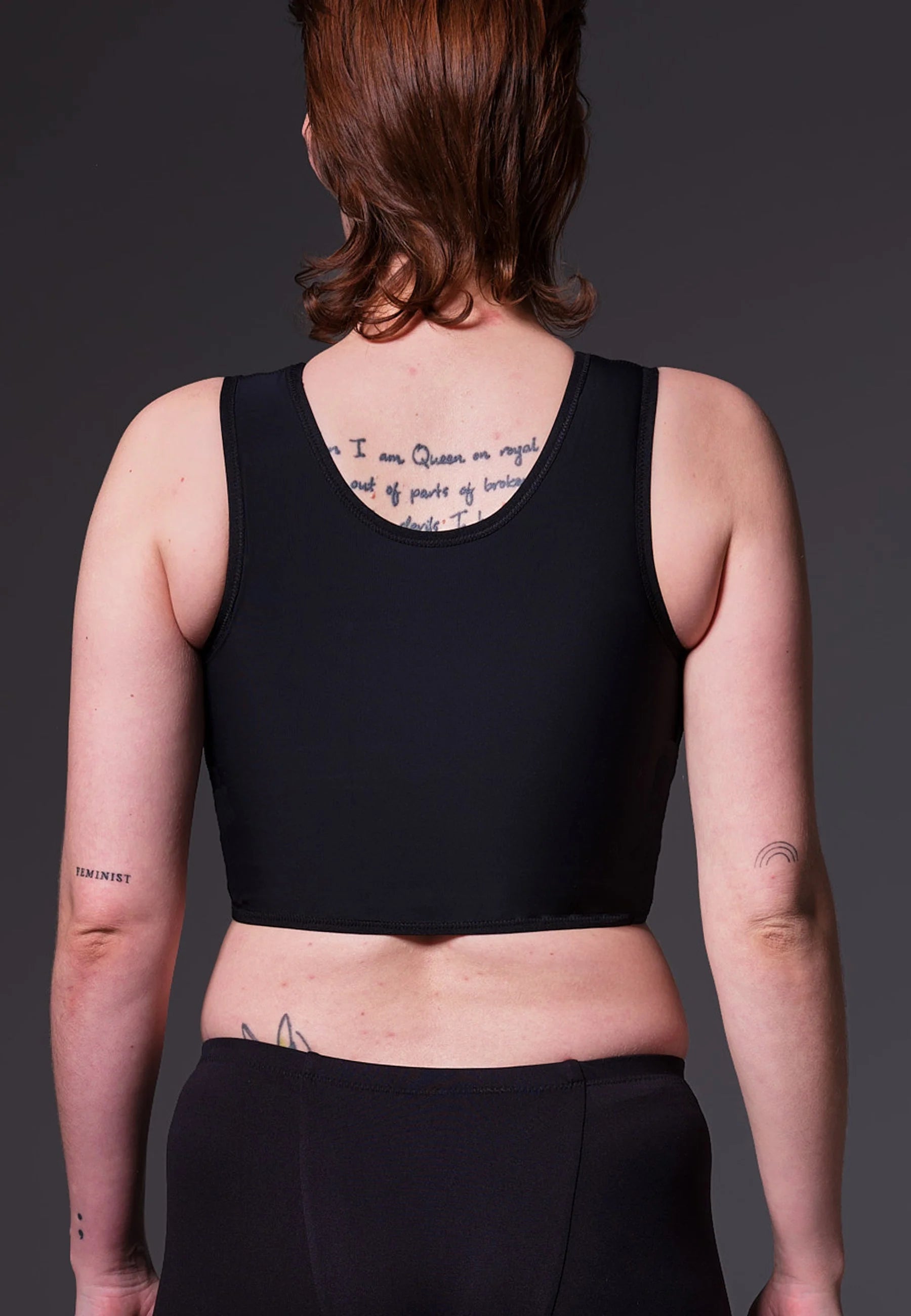 A black short chest binder designed with a round neckline, discreet seams, and a supportive, comfortable fit.